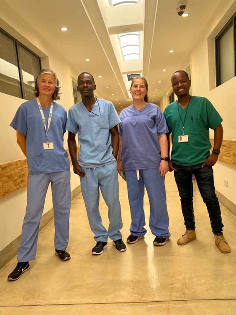 A group of medical professionals standing in a hallwayDescription automatically generated